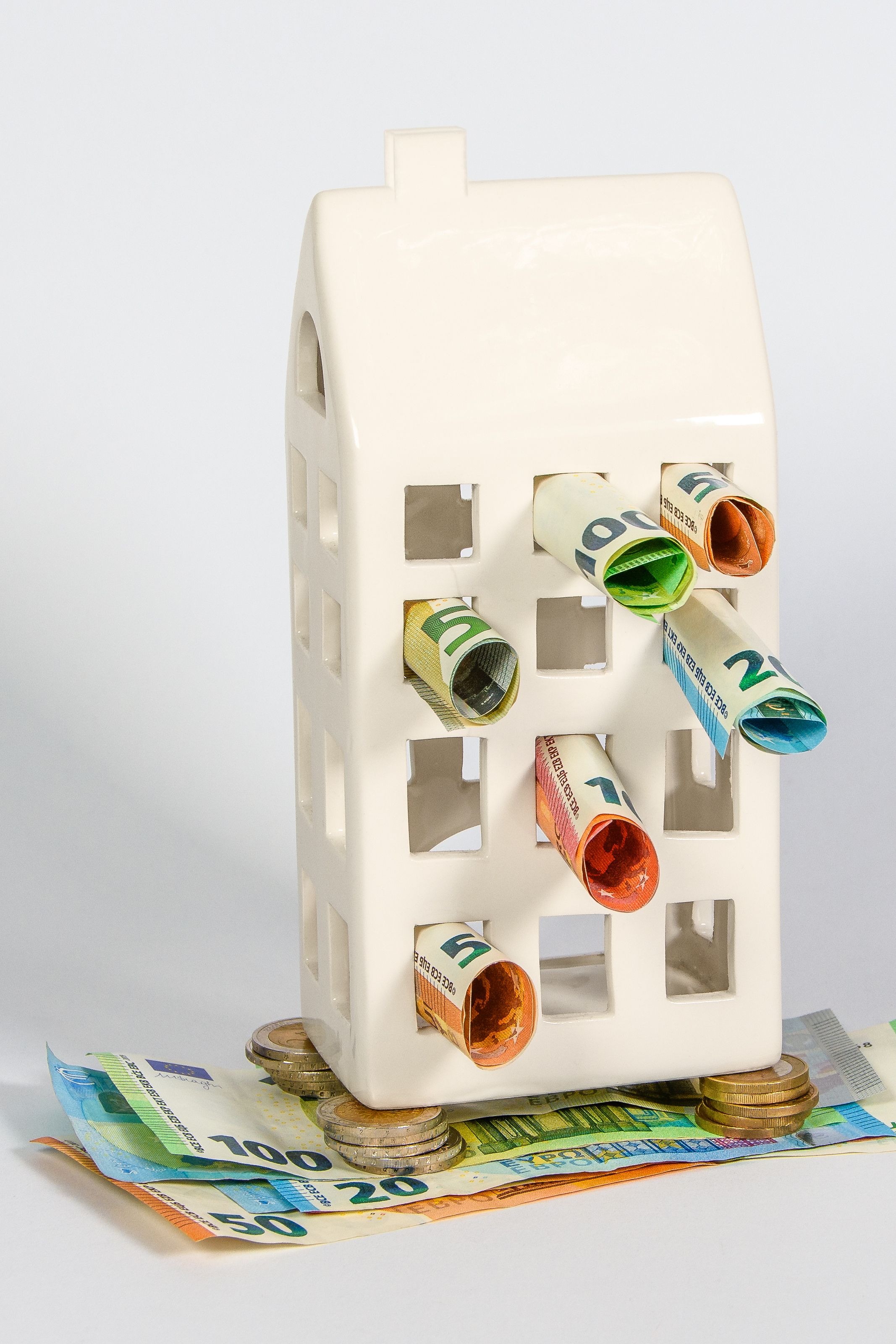 Sparhaus mit herausragenden Euro-Banknoten